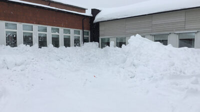 Massa snö som nästan når ända upp till skoltaket.