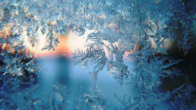 En fönsterruta som är full av iskristaller.